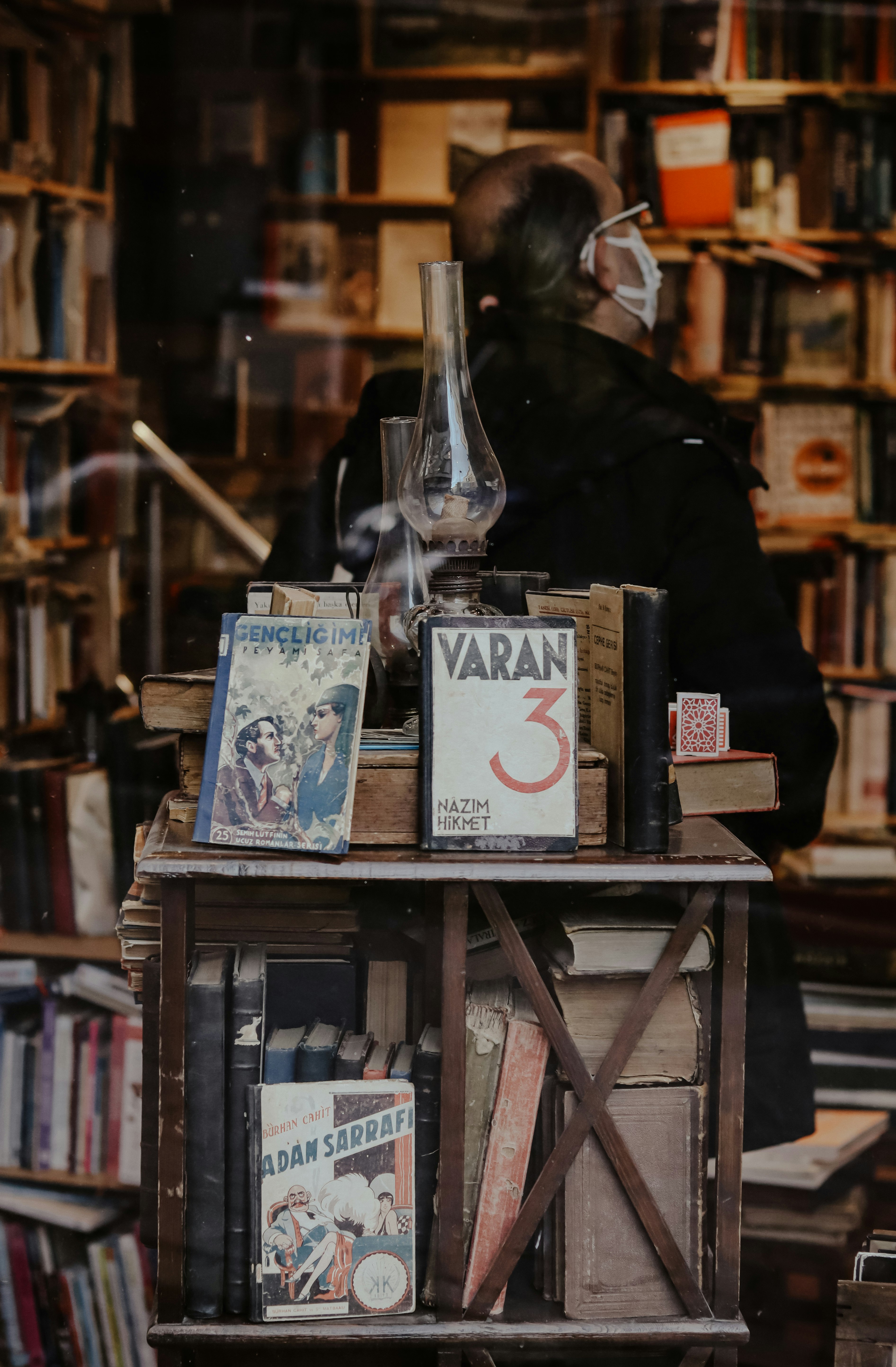 person in black coat holding white book